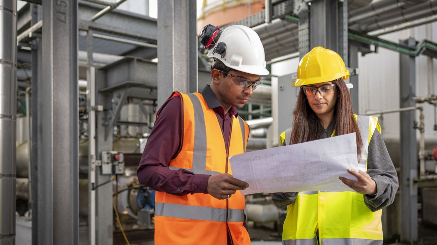 Engineers at plant looking at engineering plan