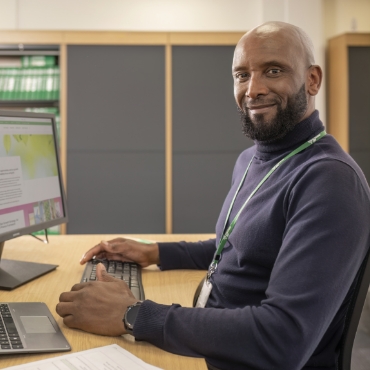 Male employee sitting at desk with computer
