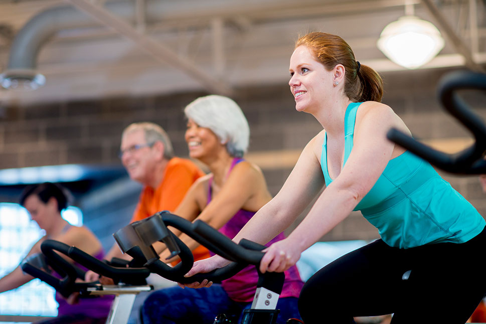 People riding stationary bikes in a gym setting